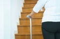 Elderly woman holding sticks while walking up stair at home,Close up