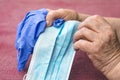 Elderly woman holding a surgical mask and medical gloves, codid-19 pandemic and corona virus Royalty Free Stock Photo