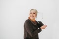 Elderly woman holding a tablet with an empty white screen and smiling. The older generation and modern technology. Royalty Free Stock Photo