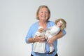 Elderly woman holding two antique dolls