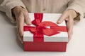 An elderly woman holds holiday box. The style of living of pensioners. Caring for the elderly.