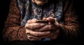 An elderly woman holds a mobile phone in her hands. Generative AI.