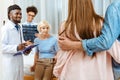 Elderly woman sitting on a hospital bed with two smiling doctors holding x-ray photo and couple of visitors standing Royalty Free Stock Photo