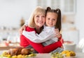 Elderly woman hugging her granddaughter while cooking festive family dinner with yummy turkey at home Royalty Free Stock Photo