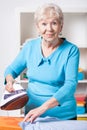 Elderly woman ironing shirt Royalty Free Stock Photo