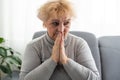 Elderly woman keeps palms in pray gesture, closes eyes, prays and asks God for health and wellness. Faith generation Royalty Free Stock Photo