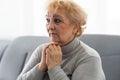 Elderly woman keeps palms in pray gesture, closes eyes, prays and asks God for health and wellness. Faith generation Royalty Free Stock Photo