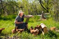 Elderly woman with laptop and chickens in village Royalty Free Stock Photo