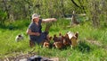 Elderly woman with laptop and chickens in village Royalty Free Stock Photo