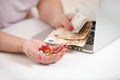 Elderly woman with laptop holding money, euro cash and pills on white table, copy space. Concept of treatment cost