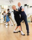 Elderly woman learning ballroom dancing movements in pair