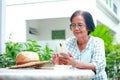 Elderly woman living at home holding a smartphone to talk online through the application She smiled happily. Royalty Free Stock Photo