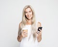 Elderly woman with long hair holding smartphone and takeaway coffee over grey color background Royalty Free Stock Photo