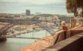 Elderly woman look at beautiful city view with river Douro and arch bridge of city Porto. Portuguese landscape