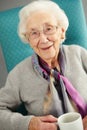 Elderly woman looking comfortable drinking tea Royalty Free Stock Photo