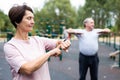 Elderly woman looking at her smart bracelet in open-air sports area Royalty Free Stock Photo