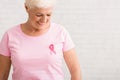 Elderly Woman Looking At Pink Cancer Ribbon On T-Shirt, Indoor Royalty Free Stock Photo