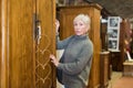 Elderly woman looking for wooden wardrobe in furnishing store Royalty Free Stock Photo