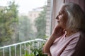 An elderly woman looks sadly out the window. Royalty Free Stock Photo