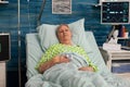 Elderly woman lying in nursing home bed Royalty Free Stock Photo