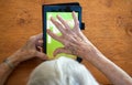 Elderly Woman Making a Solitaire Move on a Tablet Royalty Free Stock Photo