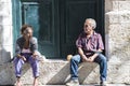 Elderly couple resting on plinth in Havana, Cuba