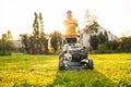 Elderly woman mows the lawn with an electric lawn mower on allotment Royalty Free Stock Photo