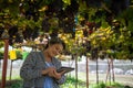 elderly woman owner of a vineyard is using a tablet to work and check the quality of grapes and fruit in the vineyard Royalty Free Stock Photo