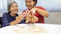 Elderly woman playing alphabet games for improve mental health and memory with daughter