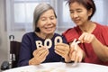 Elderly woman playing alphabet games for improve mental health and memory with daughter