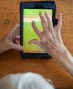 Elderly Woman Playing Solitaire on a Tablet Royalty Free Stock Photo