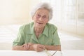 An elderly woman portrait holding glasses in her living room