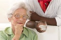 An elderly woman portrait holding glasses in her living room Royalty Free Stock Photo