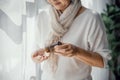 Elderly woman pouring capsule from pill bottle, taking antidepressant medication, senior citizen medicine, medical treatment plan Royalty Free Stock Photo