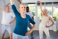 Elderly woman practicing vigorous dance during group class