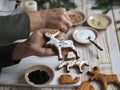 An elderly woman prepares for the holiday of Christmas or New year and is engaged in decorating homemade cookies in the form of