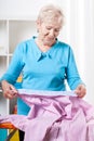 Elderly woman preparing shirt to ironing