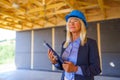 Elderly woman with protective helmet working as an architect doing expertise at construction of ecological renewable low