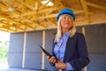 Elderly woman with protective helmet working as an architect doing expertise at construction of ecological renewable low