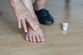 Elderly woman putting cream on swollen feet