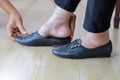 Elderly woman putting on shoes with care giver.