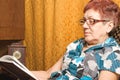 Elderly woman reading a book.