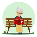 Elderly woman reads the Bible while sitting on a park bench. Royalty Free Stock Photo