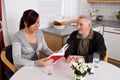 Elderly woman reads from a book.