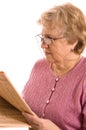 The elderly woman reads the newspaper