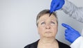 An elderly woman at the reception of a facial plastic surgeon. Consultation on the removal of age wrinkles on the face. The doctor Royalty Free Stock Photo