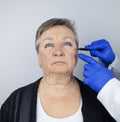 An elderly woman at the reception of a facial plastic surgeon. Consultation on the removal of age wrinkles on the face. The doctor Royalty Free Stock Photo