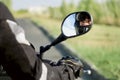 An elderly woman rides a motorcycle. Reflection in the mirror while riding a motorcycle