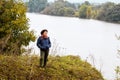 Elderly woman by the river in autumn while walking