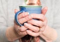 Elderly woman`s hands holding a hot drink Royalty Free Stock Photo